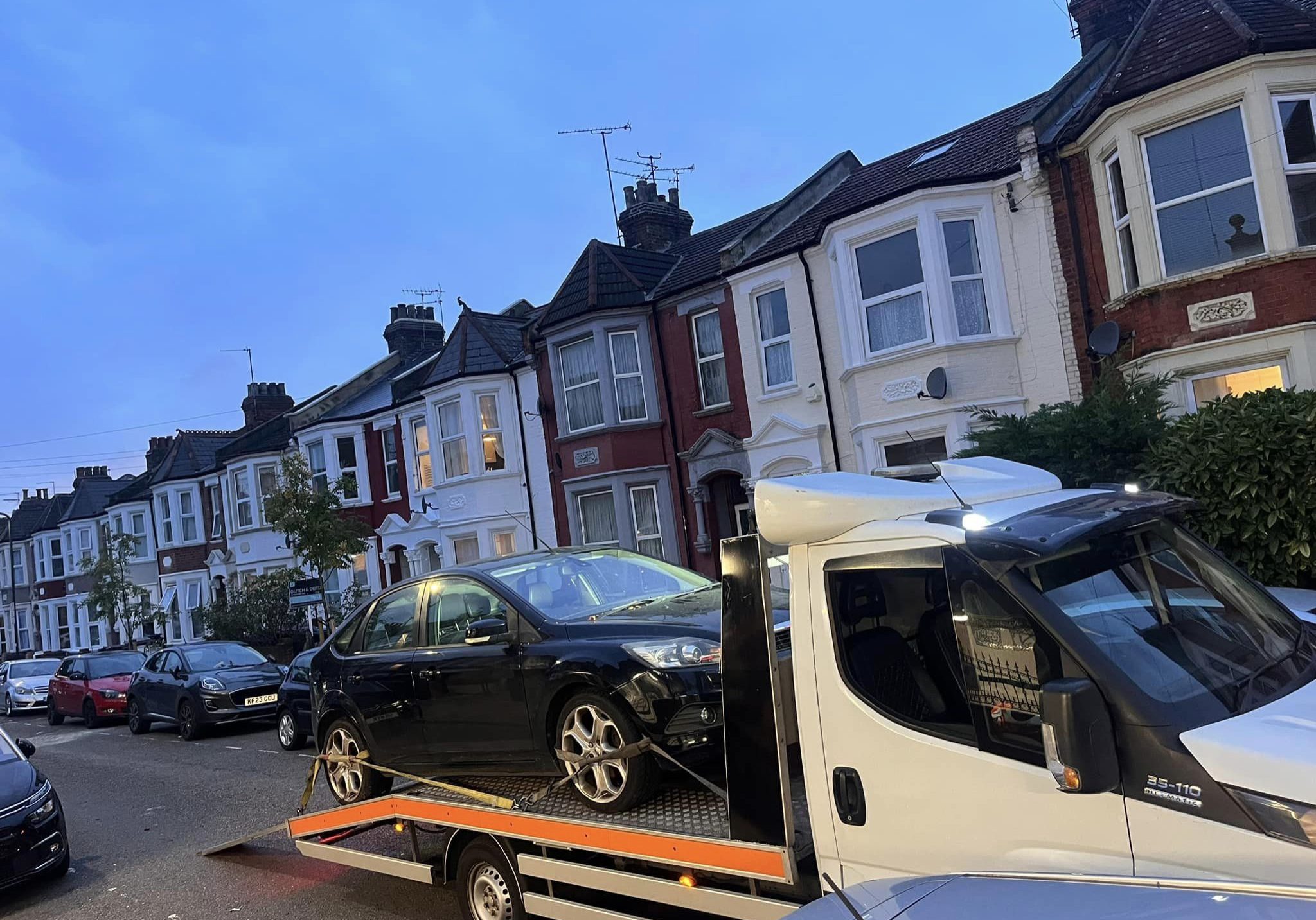 Ford Mondeo on recovery truck at night